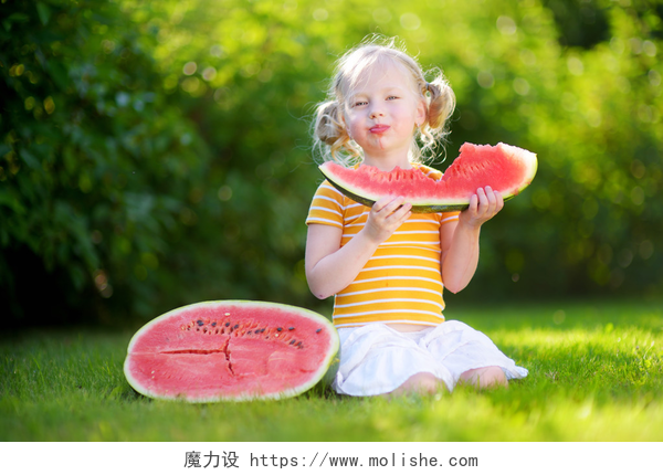 在草地上吃西瓜的女孩小女孩咬西瓜